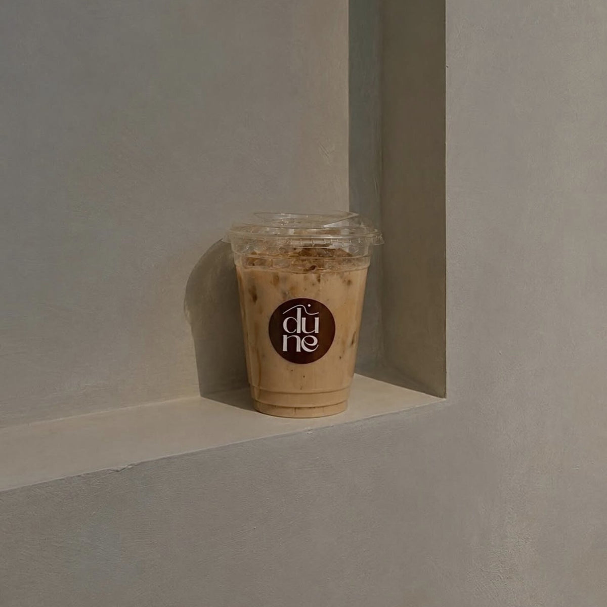 Un latte glacé Dune posé dans la niche du café
